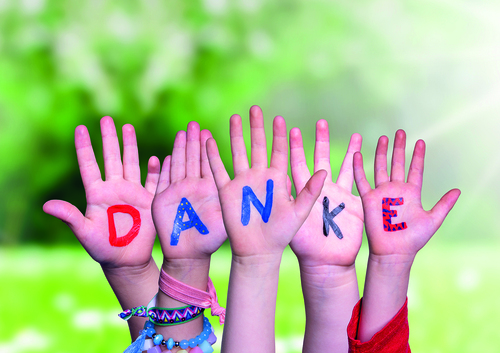 Kids Hands Holding Word Danke Euch Allen Means Thank You All, Grass Meadow / Nelos - stock.adobe.com Kids Hands Holding Colorful German Word Danke Euch Allen Means Thank You All. Sunny Green Grass Meadow As Background